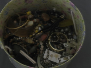 A circular cardboard box containing a collection of costume jewellery