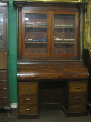 A Victorian mahogany cylinder bureau bookcase the upper section with adjustable shelves enclosed by a glazed panelled door, the base with cylinder bureau and pedestals fitted 6 long drawers (made up) 44"