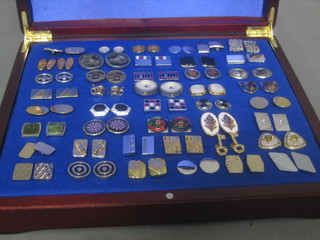 A collection of various cufflinks contained in a mahogany box
