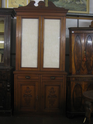 A Victorian walnut bookcase on cabinet with broken pediment, fitted shelves enclosed by glazed panelled doors, the base fitted 2 long drawers and double cupboard, raised on a platform base 40"