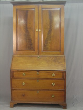 A Georgian mahogany bureau bookcase, the upper section with moulded cornice, the interior fitted shelves and 4 short drawers enclosed by panelled doors, the fall front revealing a well fitted interior above 3 long drawers raised on bracket feet 42"