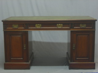 A Victorian walnut kneehole pedestal desk with inset tooled green leather writing surface, the frieze fitted 1 long and 2 short drawers, the pedestals fitted a pair of cupboards enclosed by panelled doors 54"