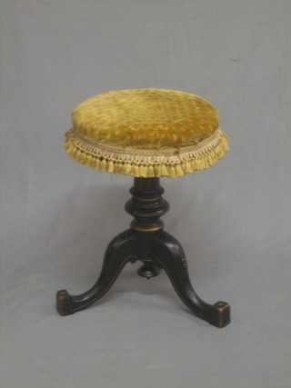 A Victorian ebonised revolving adjustable piano stool raised on pillar and tripod supports