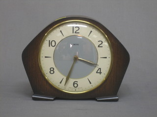A 1950's mantel clock with silvered dial contained in an oak arch shaped case by Smiths