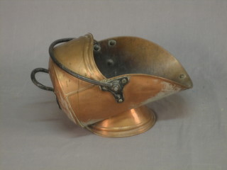A War Office issue copper helmet shaped coal scuttle with iron handle
