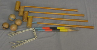 A childs croquet set comprising 6 hoops, 4 balls and 4 mallets contained in a wooden box