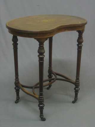 An Edwardian inlaid mahogany kidney shaped occasional table, the top inlaid musical trophies raised on turned and fluted supports with tracery work stretcher 24"