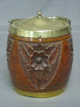 A carved oak biscuit barrel with silver plated mounts