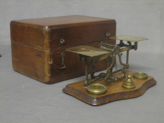 A pair of brass letter scales complete with weights contained in a mahogany case