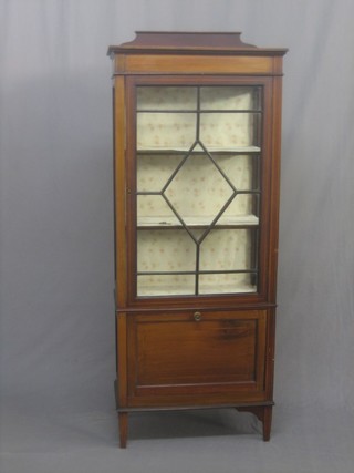 An Edwardian inlaid mahogany display cabinet/Canterbury, the upper section fitted shelves enclosed by astragal glazed doors, the base fitted a Canterbury drawer with fall front, raised on square tapering supports 25"