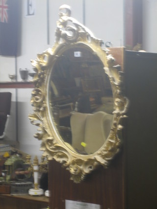 A 19th Century oval plate wall mirror contained in a decorative carved gilt wood frame 30"