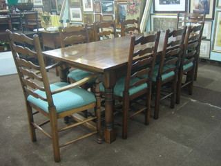 A 20th Century oak and elm dining suite comprising rectangular refectory dining table raised on turned and block supports together with 8 ladder back dining chairs