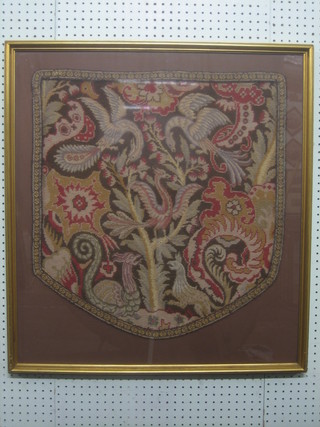 A Victorian shield shaped Berlin wool work banner decorated flowers and mythical beasts 24" x 23"