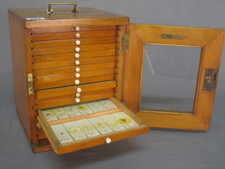 A 19th Century pine microscope slide cabinet of 17 drawers, the drawers containing 60 various slides by Flatter & Granett Ltd of Manchester