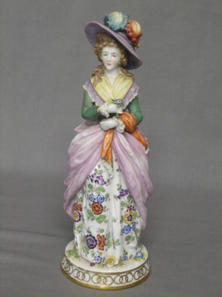 A porcelain figure of a standing bonnetted lady 9 1/2"