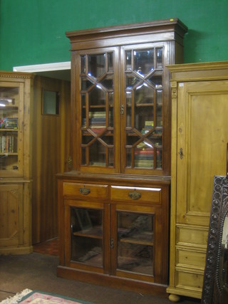 A Victorian walnut bookcase on cabinet, the upper section with moulded cornice, the interior fitted adjustable shelves enclosed by bevelled plate astragal glazed doors the base fitted 2 short drawers above a double cupboard 42"