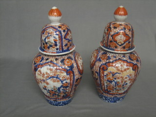 A handsome pair of 19th Century Japanese Imari porcelain urns and covers 14"
