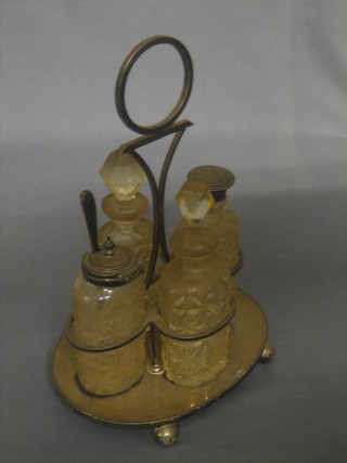 A silver plated cruet frame with 4 cut glass bottles, raised on bun feet (1f),