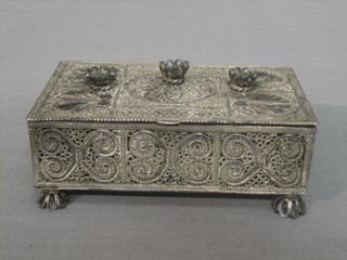 A rectangular Eastern silver filigree trinket box raised on 4 pierced supports with hinged lid 11 ozs