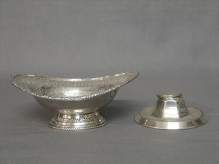 A circular silver plated inkwell with hinged lid 4", an oval silver plated pierced boat shaped bowl 7"