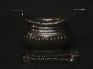 An oval silver twin handled sugar bowl, Birmingham 1914 and a pair of sugar tongs 7 ozs