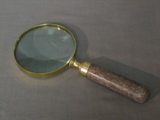 A gilt framed magnifying glass with polished stone handle