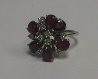 An 18ct white gold or platinum dress ring set 6 tear drop cut rubies supported by diamonds
