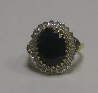 A lady's gold dress ring set a large oval sapphire supported by diamonds