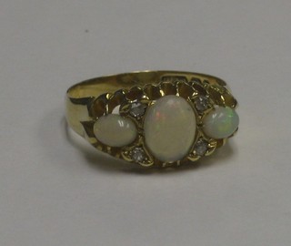 A lady's Edwardian yellow gold dress ring set 3 oval opals supported by 4 diamonds