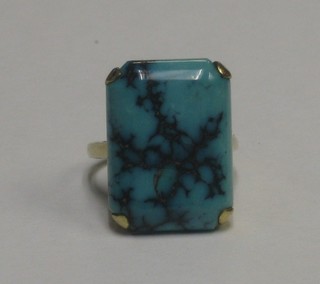 A gold dress ring set a rectangular section of turquoise