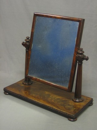 A William IV rectangular plate dressing table mirror contained in a mahogany swing frame, raised on a rectangular base with bun feet 27"