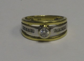 An 18ct gold dress ring set a diamond and 10 diamonds to the shoulders