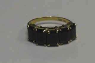 A gold dress ring set rectangular black cut stones