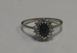 A 9ct white gold dress ring set an oval cut sapphire supported by diamonds