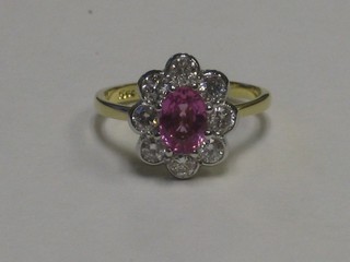 An 18ct white gold dress ring set an oval cut pink sapphire supported by diamonds, approx 0.75ct