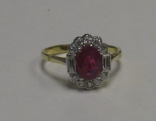 A lady's 18ct yellow gold dress ring set an oval cut ruby having 2 baguette cut diamonds to the shoulders supported by numerous diamonds