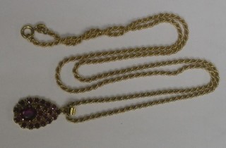 An 18ct gold chain hung a pendant set red stones