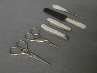 2 silver bladed fruit knives with mother of pearl grips, 2 pairs of steel scissors, a bodkin and a mother of pearl handled butter knife