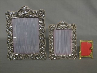 A modern embossed silver easel photograph frame 9" x 7", a smaller ditto and an Art Nouveau style frame 