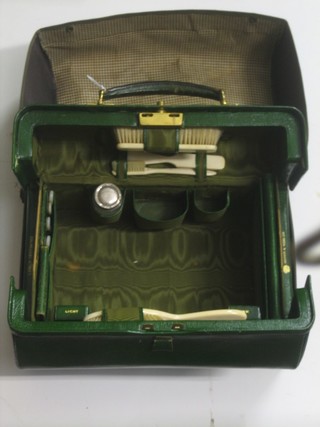 A Mappin & Webb green leather travelling case fitted 4 mother of pearl handled manicure implements, an ivory backed hair brush, do. clothes brush and 2 other brushes