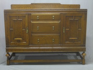 A 1930's honey oak carved sideboard fitted 3 long drawers flanked by a pair of cupboards, raised on bulbous turned supports 53"