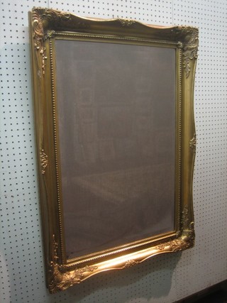 A rectangular bevelled plate wall mirror contained in a decorative gilt frame 36" x 26"