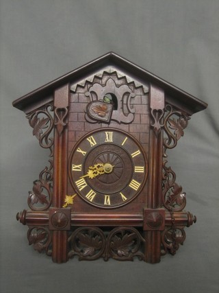 A 19th/20th Century cuckoo clock contained in a carved walnut case 