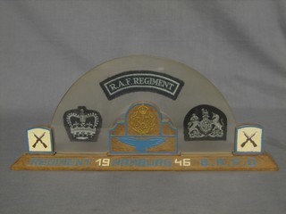 A display of Royal Air Force regiment cloth ranks contained in a fibre glass and carved oak frame marked RAF Regiment Hamburg 1946 B.A.F.O 15"