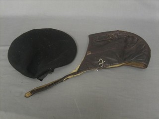A Luftwaffe brown leather flying helmet together with a black cloth beret