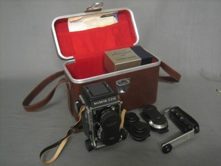 A Mamiya C220 Professional camera contained in a leather case together with various accessories