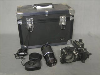 A Mamiya-Sekorc lens no. 13999 etc, contained in a metal gadget box