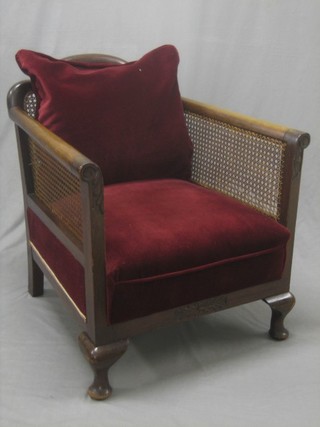 A 1930's walnut Bergere single cane chair raised on cabriole supports