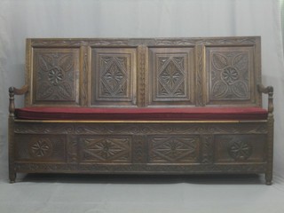 An 18th Century carved oak settle with raised back, the base with hinged lid 71"