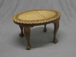 An oval carved hardwood occasional table, raised on cabriole supports 27"